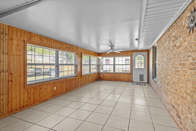 unfurnished sunroom with a wealth of natural light and ceiling fan