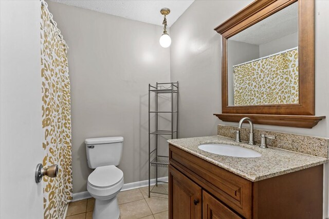 bathroom with tile patterned floors, vanity, a textured ceiling, and toilet