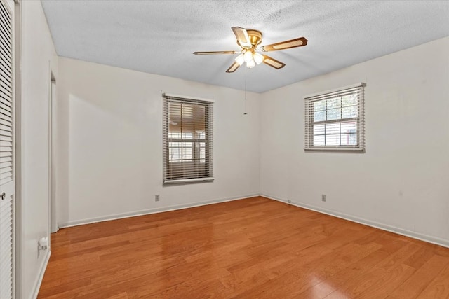 unfurnished room with a textured ceiling, light hardwood / wood-style flooring, and ceiling fan