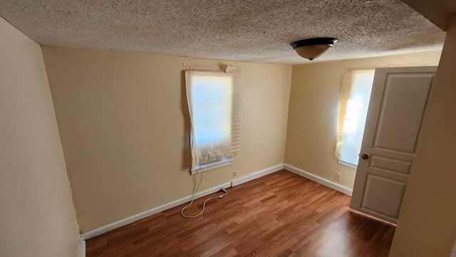 spare room with hardwood / wood-style floors and a textured ceiling