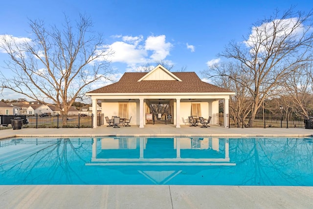 view of swimming pool featuring a patio area, an outdoor structure, and ceiling fan