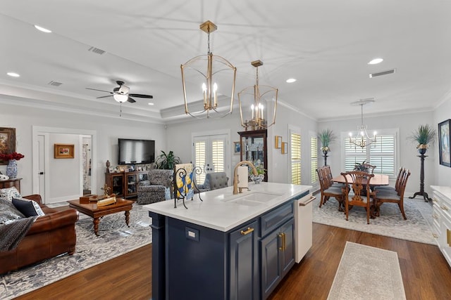 kitchen featuring french doors, decorative light fixtures, an island with sink, white dishwasher, and sink