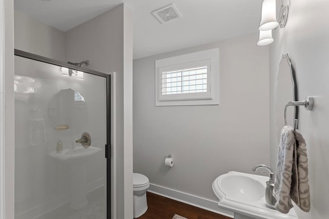 bathroom featuring sink, hardwood / wood-style flooring, toilet, and an enclosed shower