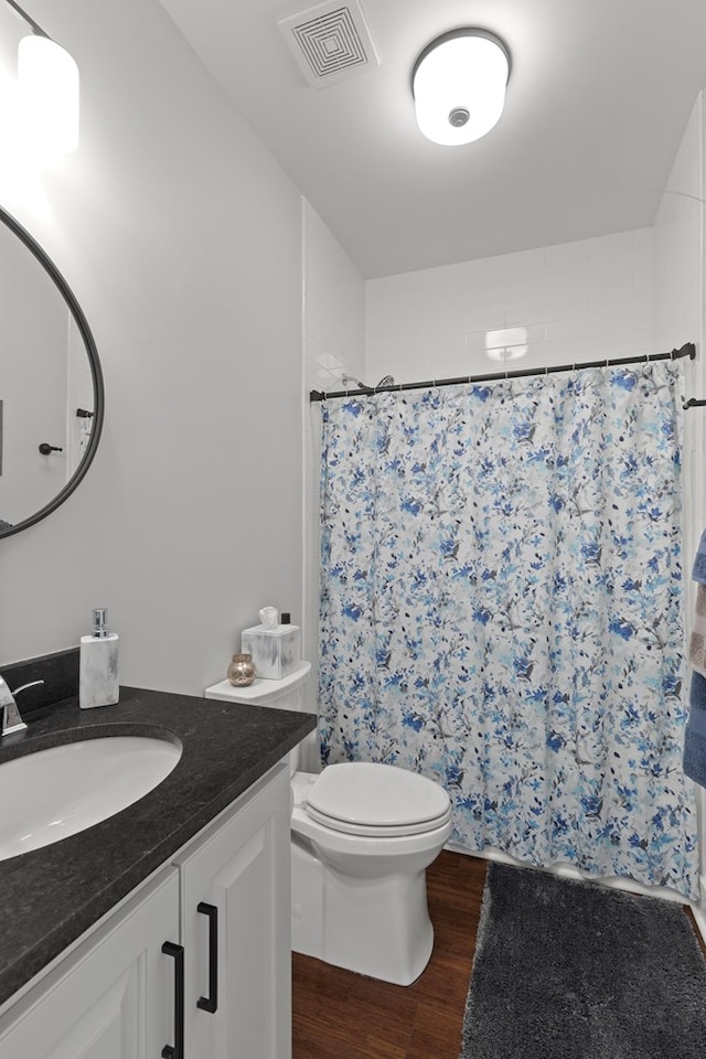 bathroom with vanity, toilet, curtained shower, and hardwood / wood-style flooring