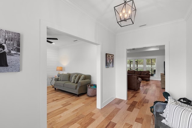 corridor featuring crown molding, a chandelier, and hardwood / wood-style flooring