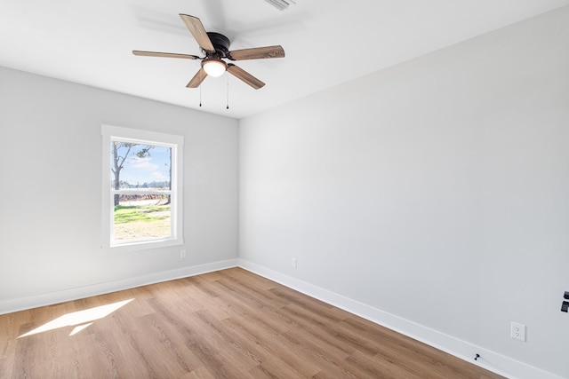 empty room with ceiling fan, light wood-type flooring, and baseboards