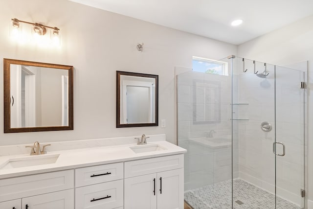 full bath featuring double vanity, a sink, and a shower stall