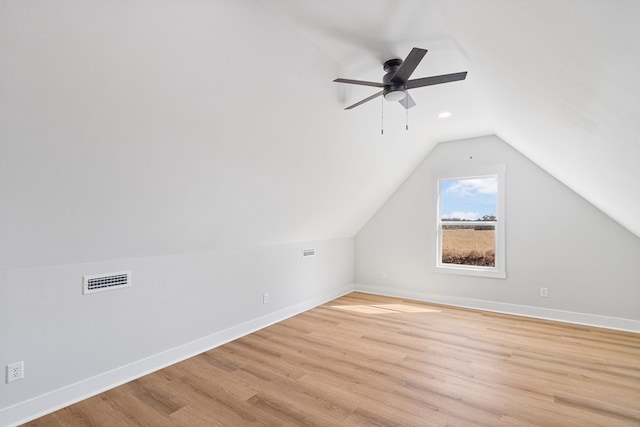 bonus room featuring light wood-style floors, vaulted ceiling, and baseboards