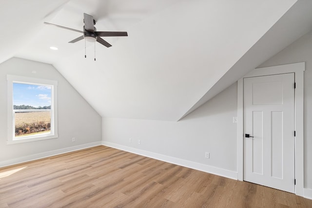 bonus room featuring light wood-type flooring, baseboards, and lofted ceiling