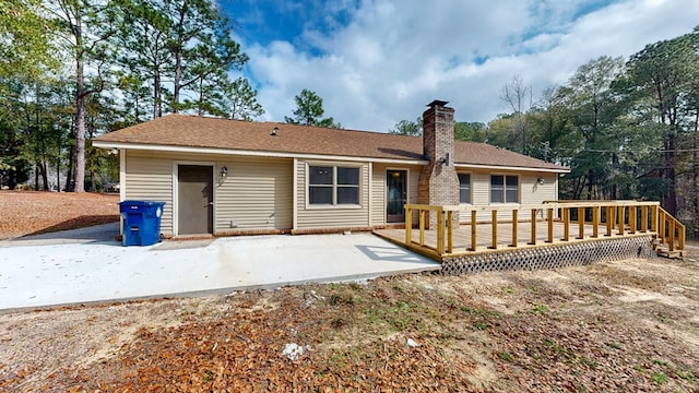 back of house featuring a deck and a patio area