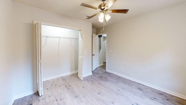 unfurnished bedroom featuring ceiling fan, light hardwood / wood-style floors, and a closet