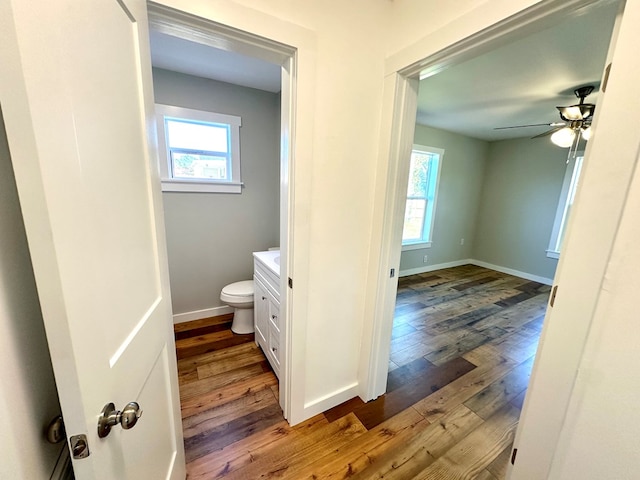 bathroom featuring vanity, hardwood / wood-style flooring, toilet, and ceiling fan