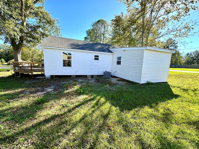 rear view of property with central air condition unit, a yard, and a deck