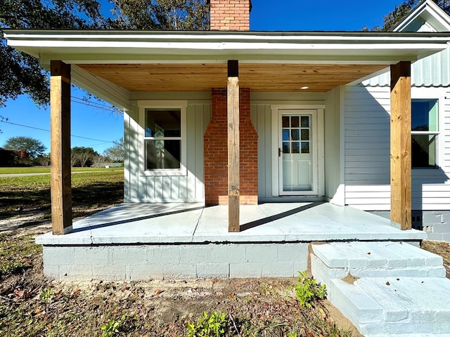 view of exterior entry featuring covered porch