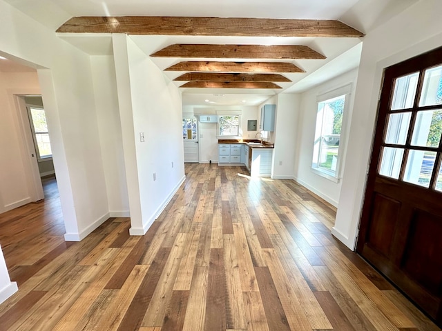 foyer entrance featuring beamed ceiling and light hardwood / wood-style floors