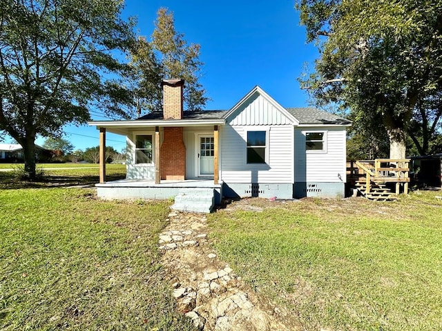 back of property featuring a lawn and a porch