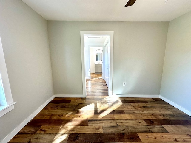 empty room with dark hardwood / wood-style floors and ceiling fan