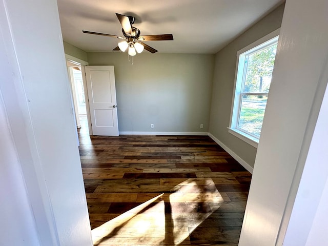 unfurnished room with ceiling fan and dark wood-type flooring