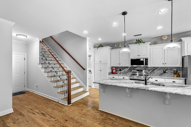 401 Gladstone Way, Dothan, AL 36303 - kitchen featuring appliances with stainless steel finishes, ornamental molding, a kitchen breakfast bar, recessed lighting, and white cabinets