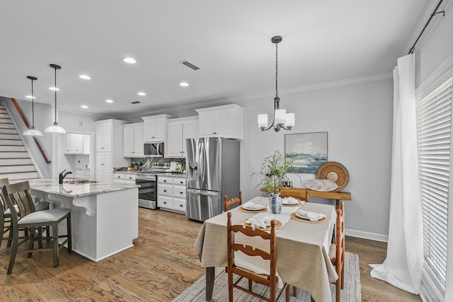 401 Gladstone Way, Dothan, AL 36303 - kitchen featuring appliances with stainless steel finishes, ornamental molding, recessed lighting, white cabinetry, and light wood-style floors