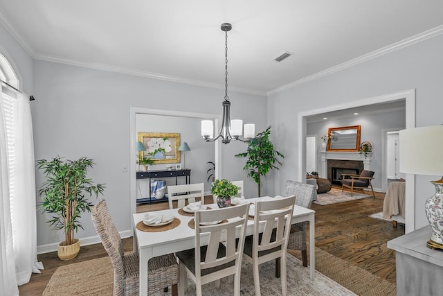 401 Gladstone Way, Dothan, AL 36303 - dining space with ornamental molding, dark wood-type flooring, a chandelier, and a fireplace