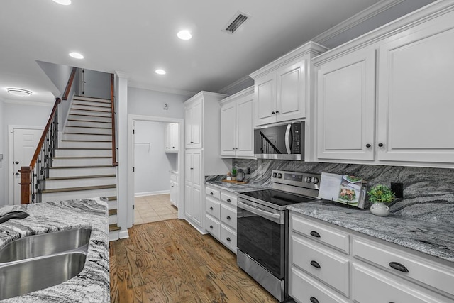 401 Gladstone Way, Dothan, AL 36303 - kitchen with stainless steel appliances, crown molding, white cabinets, recessed lighting, and backsplash