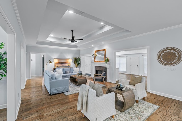 401 Gladstone Way, Dothan, AL 36303 - living room featuring a tray ceiling, crown molding, a ceiling fan, a tiled fireplace, and wood finished floors