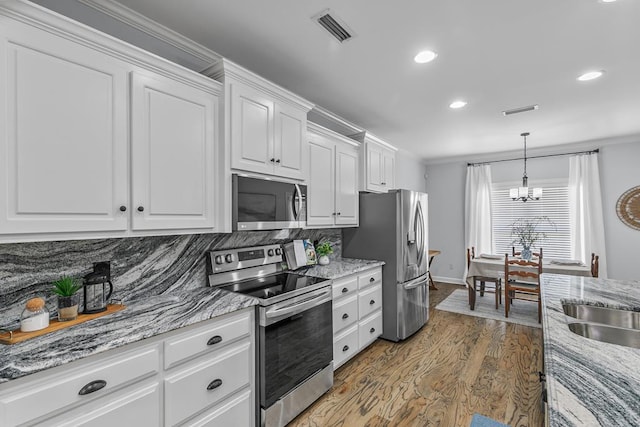401 Gladstone Way, Dothan, AL 36303 - kitchen with appliances with stainless steel finishes, wood finished floors, a chandelier, white cabinets, and tasteful backsplash