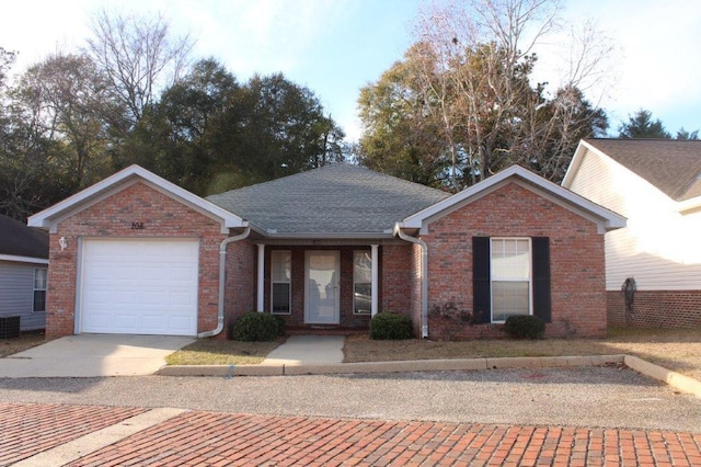 single story home with central AC unit and a garage