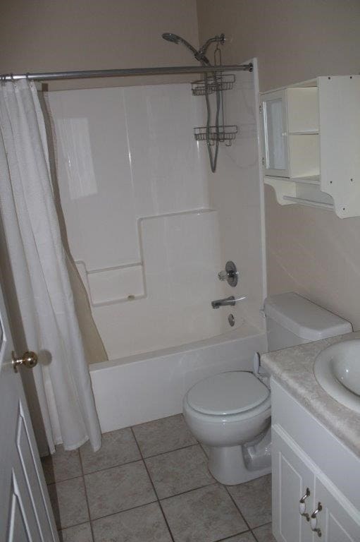 full bathroom with toilet, vanity, tile patterned flooring, and shower / bath combo with shower curtain