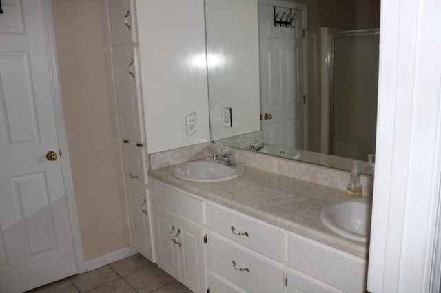 bathroom with tile patterned floors, vanity, and walk in shower