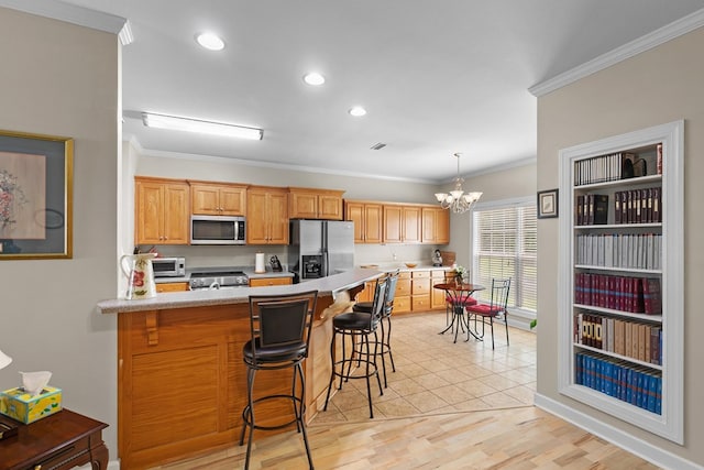 409 Drake Dr, Dothan, AL 36605 - kitchen featuring stainless steel appliances, crown molding, light countertops, a peninsula, and a breakfast bar area