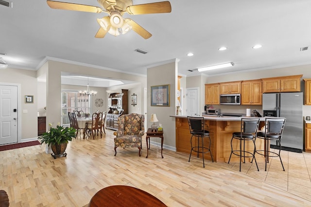 409 Drake Dr, Dothan, AL 36605 - kitchen featuring stainless steel appliances, ornamental molding, a breakfast bar, light wood finished floors, and light countertops