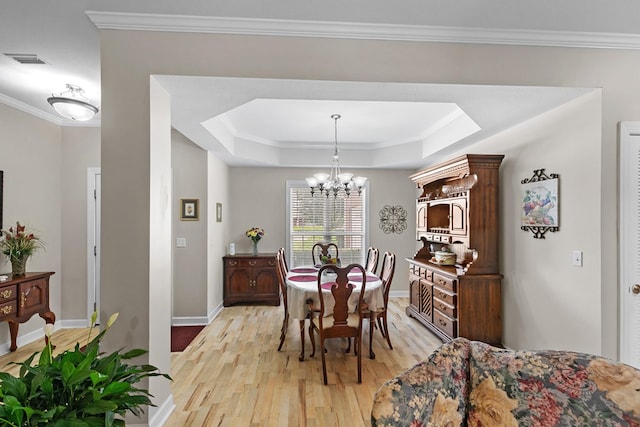 409 Drake Dr, Dothan, AL 36605 - dining room featuring light wood finished floors, a tray ceiling, ornamental molding, and a chandelier