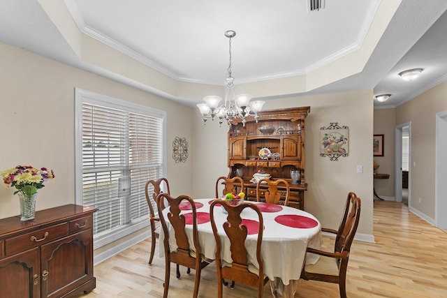409 Drake Dr, Dothan, AL 36605 - dining space with a raised ceiling, light wood-type flooring, a chandelier, and crown molding