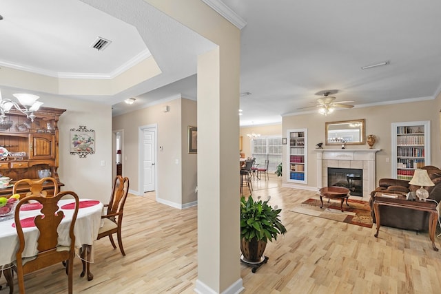 409 Drake Dr, Dothan, AL 36605 - dining space with light wood-style floors, ornamental molding, a tile fireplace, a chandelier, and ceiling fan