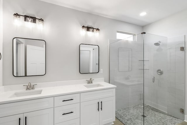 bathroom featuring double vanity, a sink, and a shower stall