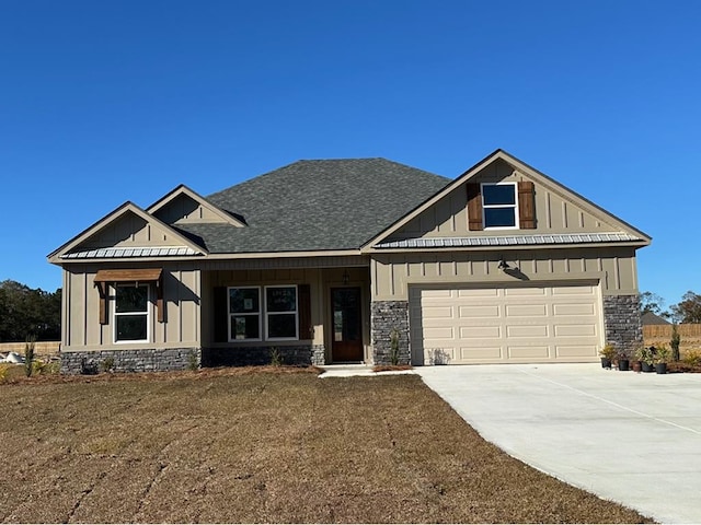 view of front facade featuring a shingled roof, board and batten siding, a garage, stone siding, and driveway