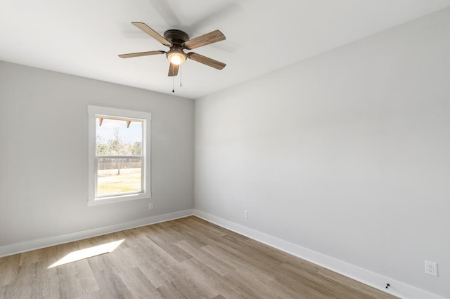 empty room with a ceiling fan, light wood-type flooring, and baseboards