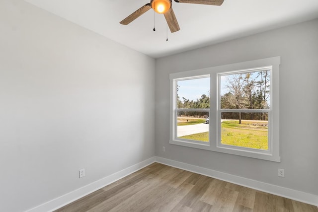 empty room featuring light wood-style floors, ceiling fan, and baseboards