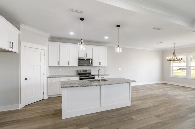 kitchen with a sink, visible vents, white cabinetry, appliances with stainless steel finishes, and a center island with sink