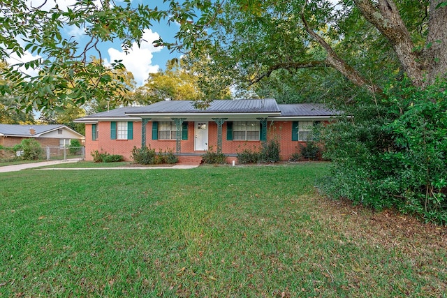 single story home featuring covered porch and a front yard