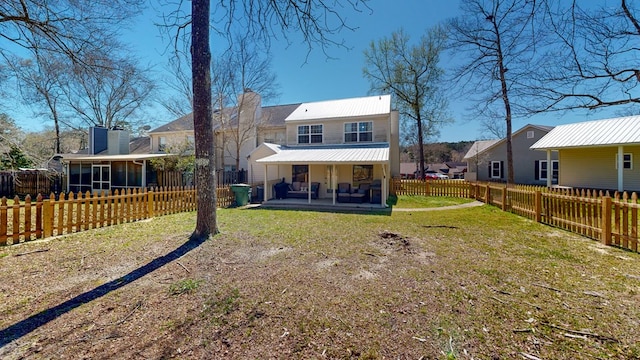 180 Fairway Woods Dr, Ozark, AL 36360 - rear view of property with a sunroom, metal roof, a patio area, and a chimney