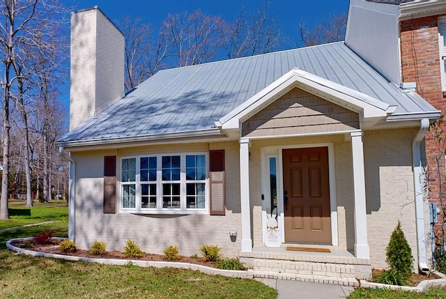 180 Fairway Woods Dr, Ozark, AL 36360 - view of front of house with a chimney, brick siding, and a standing seam roof
