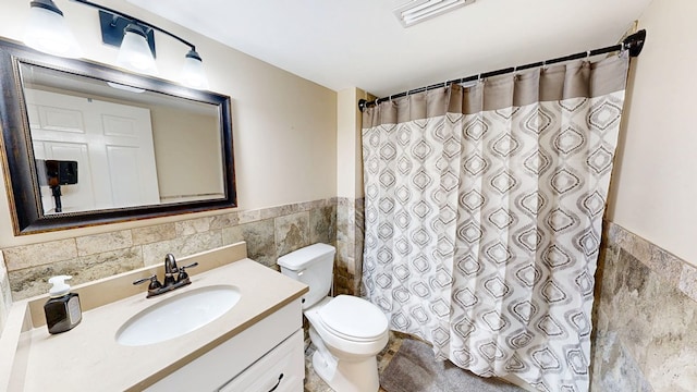 180 Fairway Woods Dr, Ozark, AL 36360 - full bath featuring tile walls, a wainscoted wall, toilet, vanity, and a shower with shower curtain