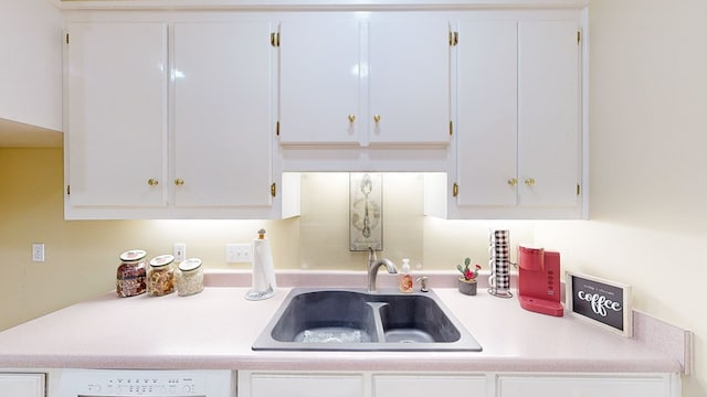 kitchen featuring washer / clothes dryer, white cabinetry, sink, and dishwasher