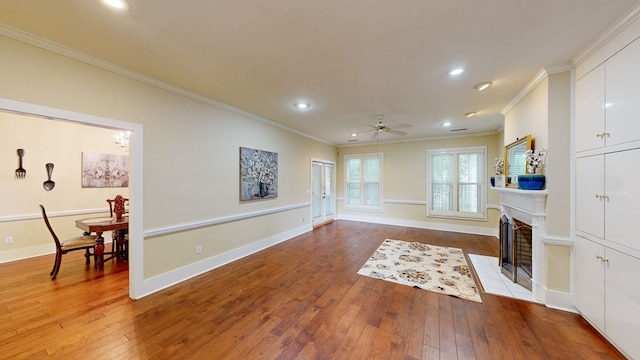 living room with light wood-type flooring, ceiling fan, and ornamental molding