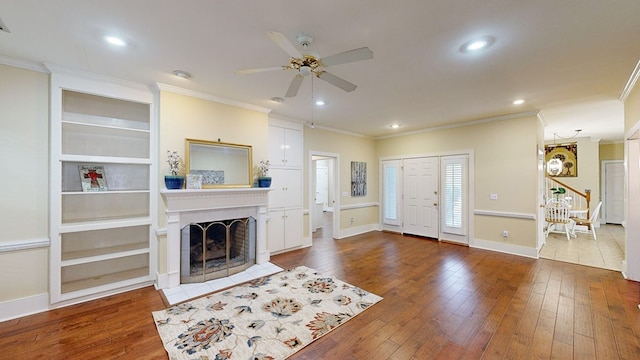 living room featuring hardwood / wood-style floors, ceiling fan, and crown molding