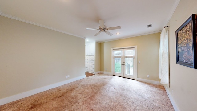 spare room featuring crown molding, french doors, ceiling fan, and light colored carpet