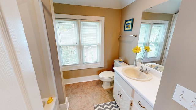 bathroom featuring tile patterned flooring, vanity, toilet, and a wealth of natural light